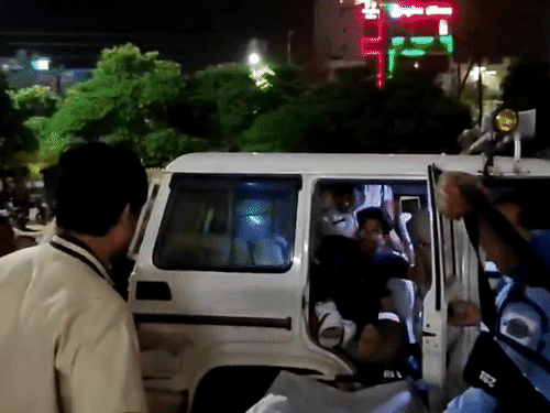 आरोपी को कार से उतारते पुलिसकर्मी।