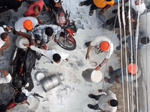 दूधाच्या कॅन रस्त्यावर उलटल्यानंतर दूधवाल्याशी वाद घालणारे शेतकरी.