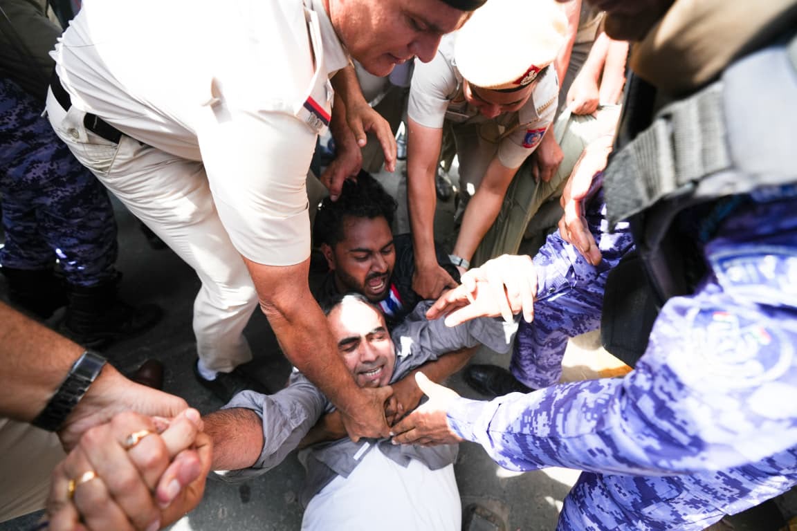 आप नेता अनुराग ढांडा को हिरासत में लेजाती हुई पुलिस।