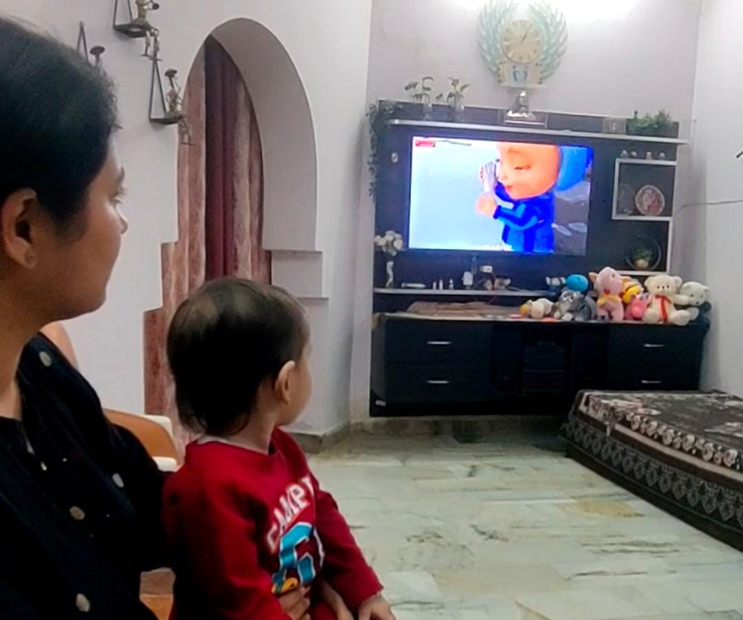 मां के साथ टीवी पर कार्टून देखते बच्ची नीलाक्षी