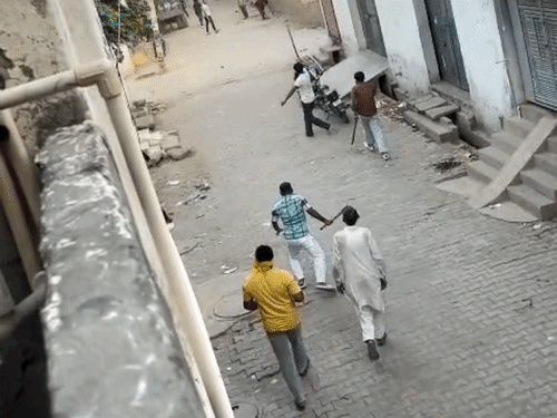 हाथों में तलवारे और धारदार हथियार लिए हुए हमलावर।