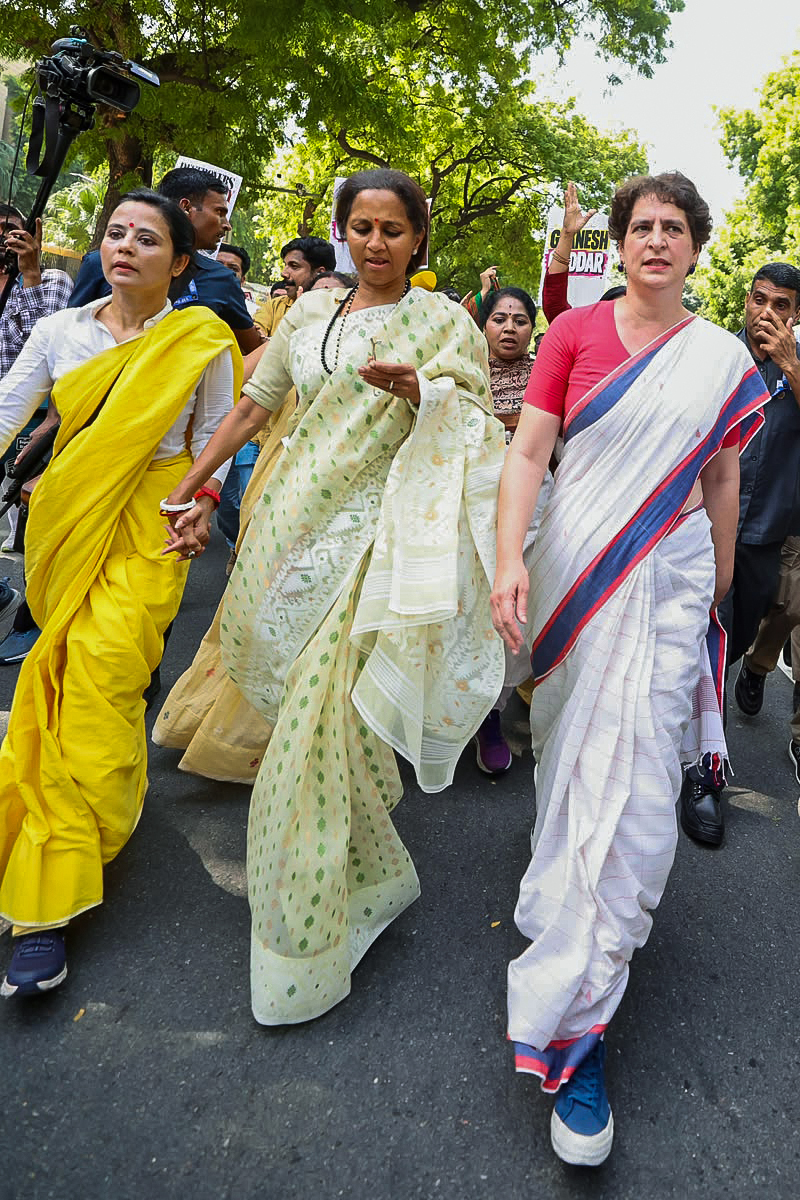 प्रोटेस्ट के दौरान TMC सांसद महुआ मोइत्रा, NCP(SP) सांसद सुप्रिया सुले और कांग्रेस सांसद प्रियंका गांधी हाथ पकड़कर चलती दिखीं।