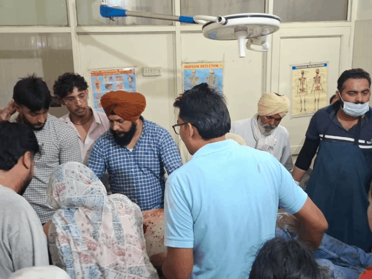 Family members stand around the sarpanch, who has been admitted to hospital.