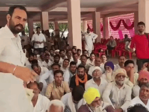 लाइन में नंबर न आने पर रोष जताते हुए किसान।