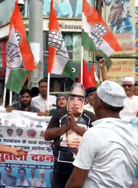 एक प्रदर्शनकारी राजभवन मार्च में CEC ज्ञानेश कुमार का मुखौटा लगाकर शामिल हुआ।