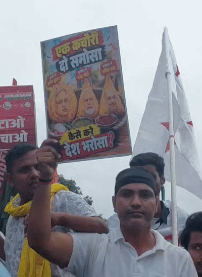 एक कचौरी दो समोसा, कैसे करे देश भरोसा.. लिखा हुए पोस्टर लेकर पहुंचे राजद कार्यकर्ता।