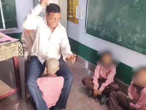सैफई के प्राथमिक विद्यालय बिरौली में प्रधानाध्यापक छात्र के सिर पर हाथ फेरते नजर आ रहे हैं।