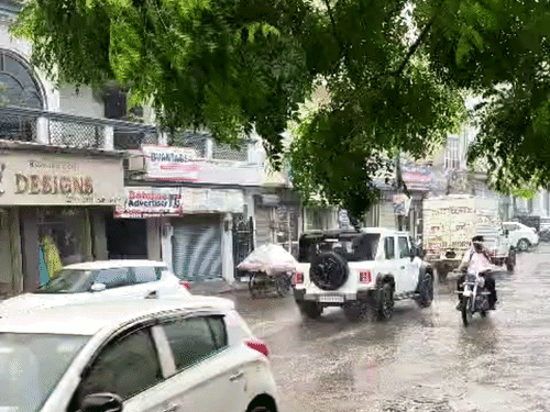 जालंधर में तेज बारिश के बीच गुजरते वाहन चालक।