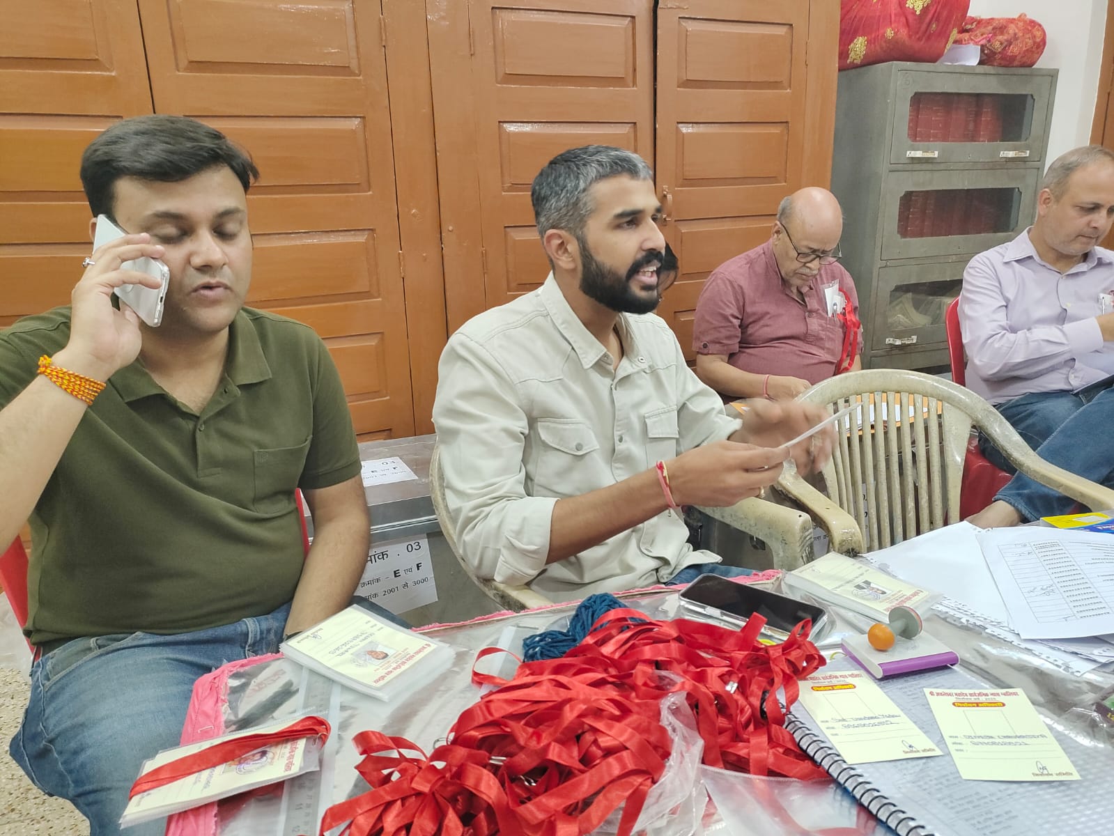 मतदान केंद्र में प्रवेश के लिए मतदाताओं को पहचान पत्र देते प्रशासनिक अधिकारी