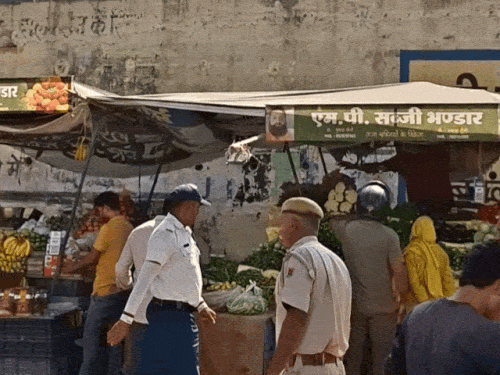 सड़क पर लगे ठेले पर कार्रवाई करती पुलिस।