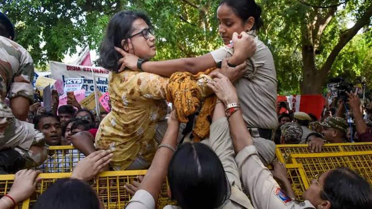 बैरिकेड पर चढ़कर नेहा ने नारेबाजी की, तो पुलिस ने उन्हें हिरासत में ले लिया।