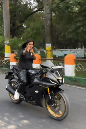 युवती बाइक पर बैठकर दोनों हाथ छोड़कर स्टंट करती नजर आ रही है।