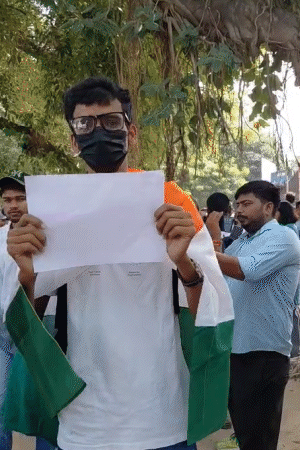पीठ पर तिरंगा बांधकर एक छात्र खाली पेज के साथ प्रोटेस्ट में पहुंचा। पूछने पर कहा, ये मोदी का विकास है, जो केवल अंधभक्तों को ही दिखेगा।