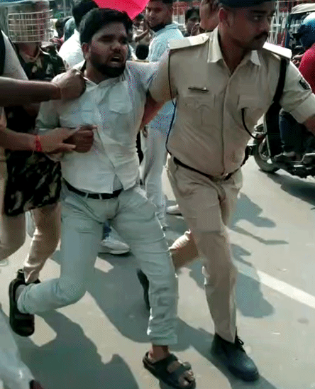 छात्र को पकड़कर ले जाती पुलिस।