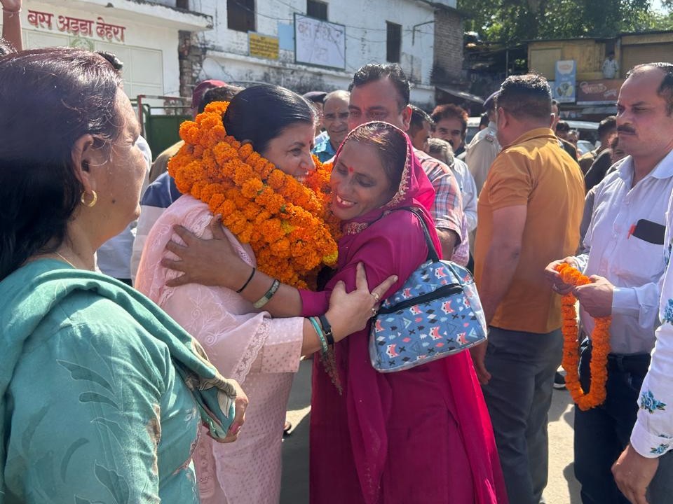 विधायक कमलेश ठाकुर को गले लगातीं एक महिला।