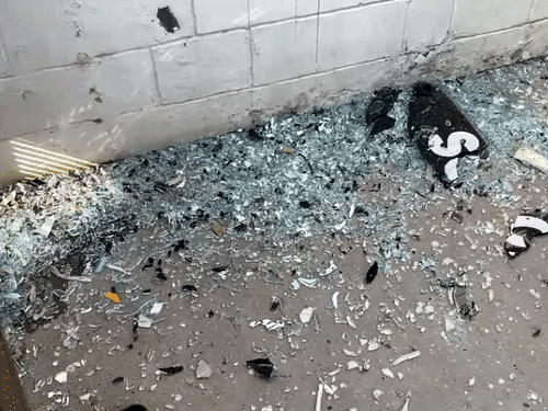 स्कूल बस के गेट से टकराने के बाद उसका शीशा टूटकर बिखर गया।