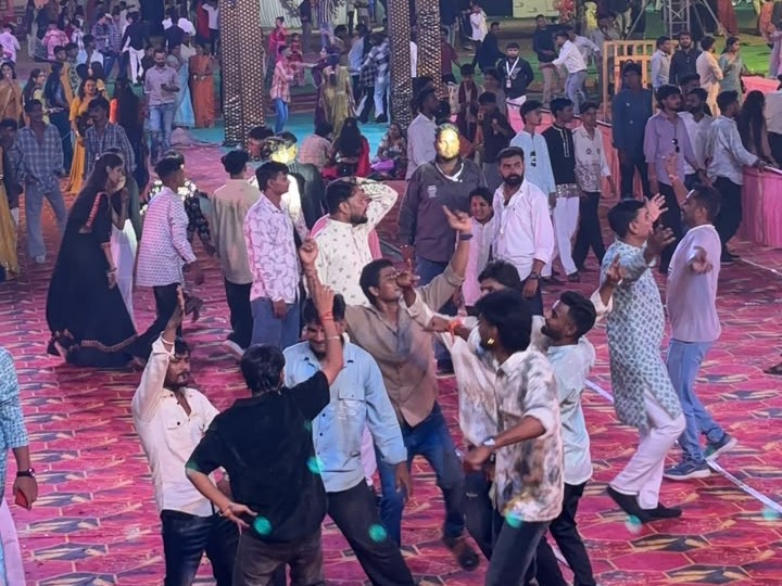 रंग-बिरंगी रोशनी और आकर्षक सजावट के बीच गरबा करते युवक-युवतियां।