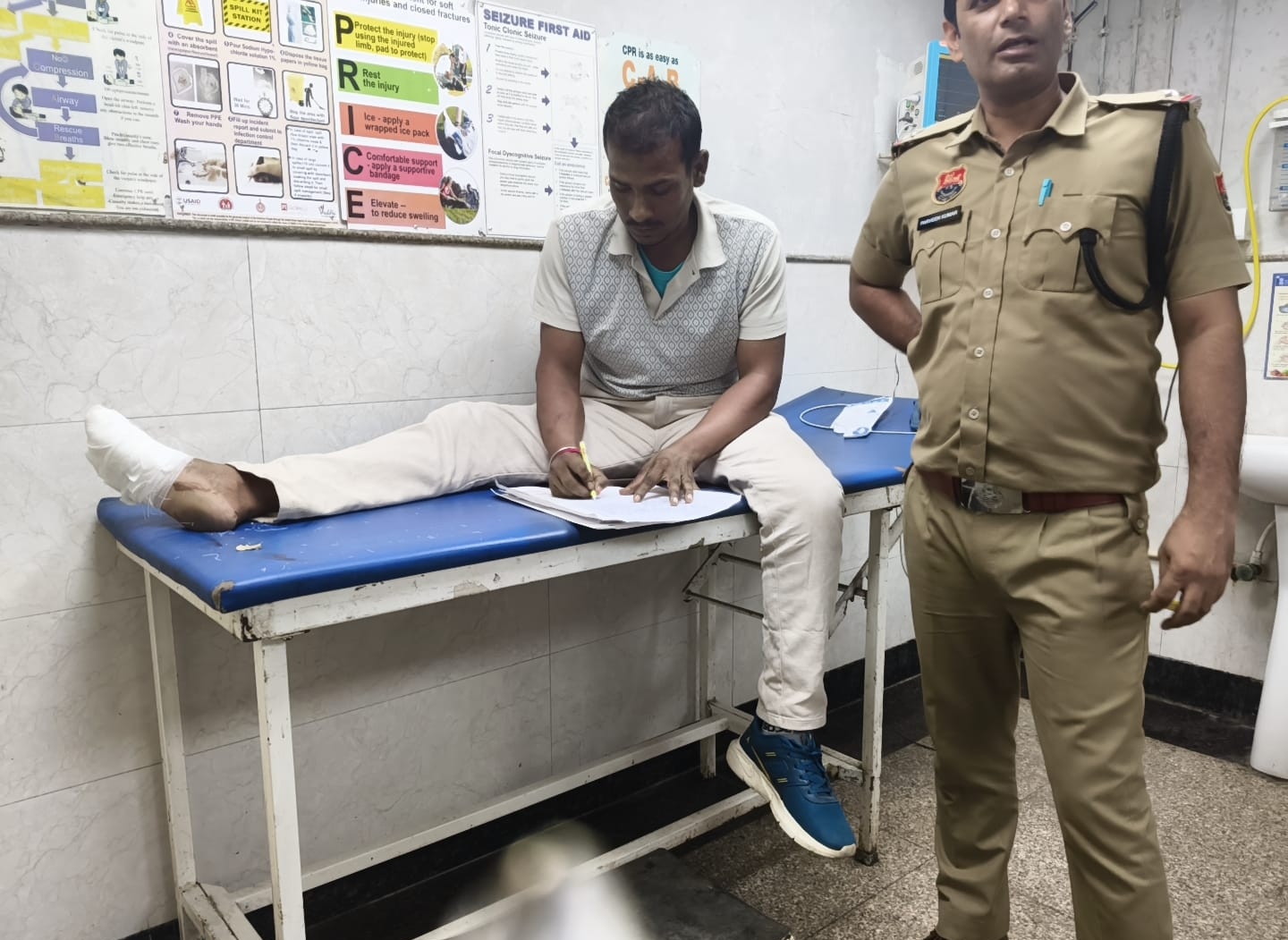 अस्पताल में उपचाराधीन घायल से जानकारी लेता पुलिसकर्मी।