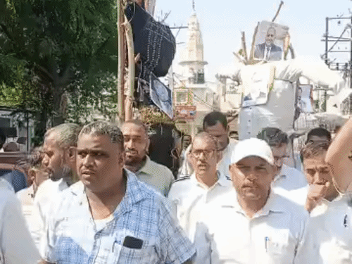 नेताओं के पुतले की शवयात्रा निकालते बिजली कर्मचारी।