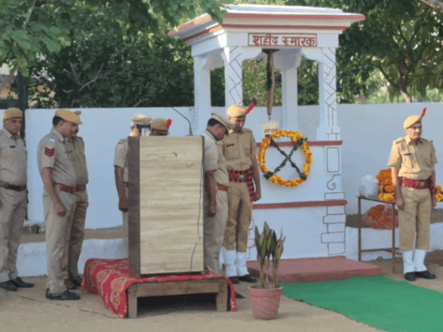 शहीदों का स्मरण करते हुए सिर झुकाए हुए पुलिस अधिकारी और जवान।