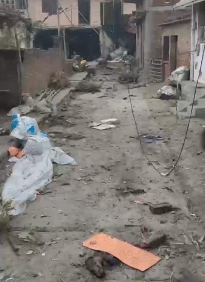 धमाके के बाद मकान के बाहर बिखरे शव।