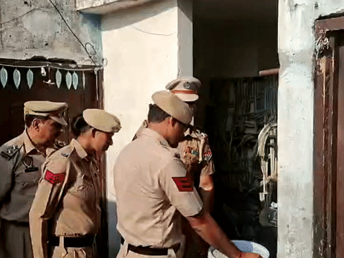 घर में चेकिंग करते पुलिसकर्मी।