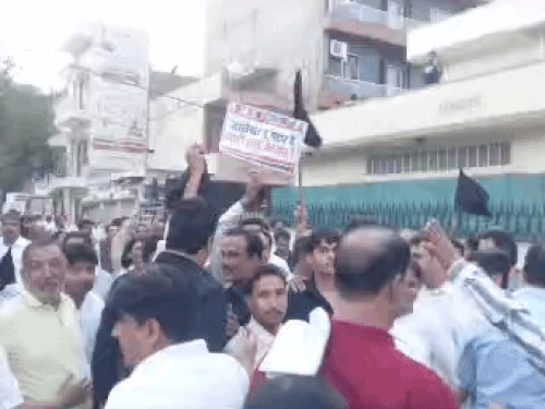 भाजपा प्रदर्शनकारियों को काले झंडे दिखाते हुए कांग्रेस कार्यकर्ता।