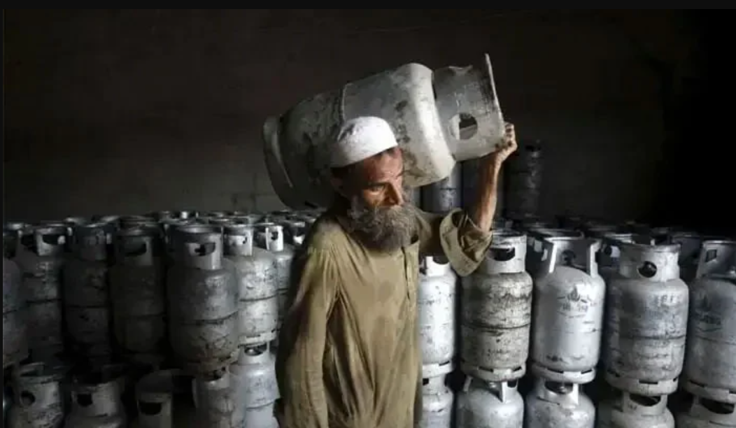 पाकिस्तान में एक शख्स सिलेंडर उठाकर ले जाता हुआ।