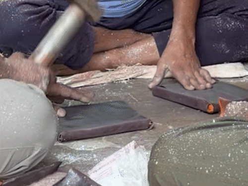 मिठाई पर लगने वाले वर्क तैयार करते हुए कारीगर।