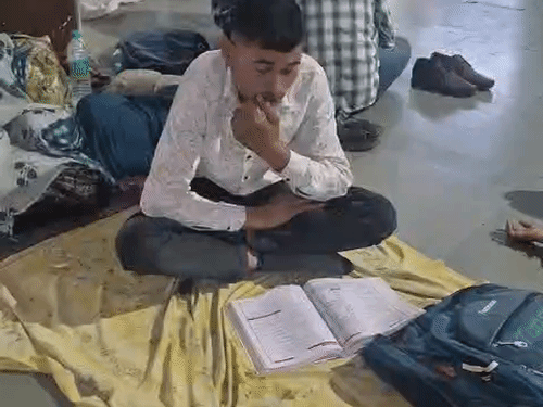 स्टेशन पर पढ़ाई करता अभ्यर्थी।