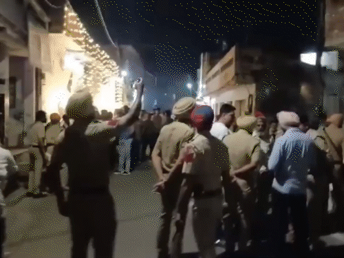 मोगा में फायरिंग के बाद मौके पर पहुंची पुलिस और शटर पर गोलियों के निशान। - Dainik Bhaskar