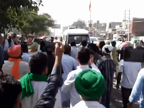 मानसा में बुधवार को पुलिस की गाड़ी को घेरते लोग। कल मंगलवार को पुलिस दलजीत की लाश उठाकर ले गई थी। - Dainik Bhaskar