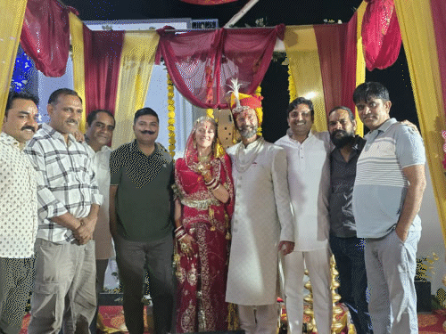 दुजोद गांव के सरपंच और शादी में शामिल लोगों के साथ फोटो खिंचवाते हुए दुल्हा-दुल्हन।