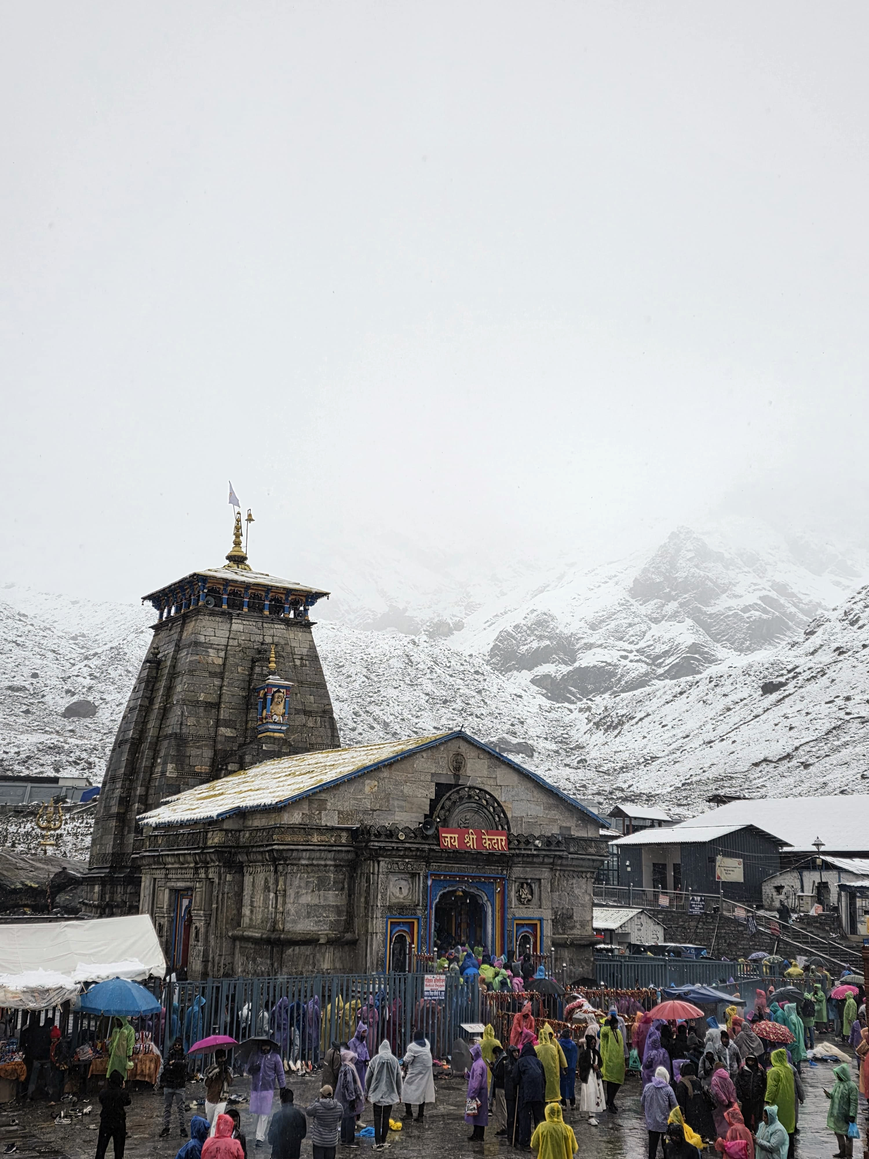 रुद्रप्रयाग में लगातार बर्फबारी के बाद, बर्फ से ढके केदारनाथ धाम परिसर में मौजूद श्रद्धालु।