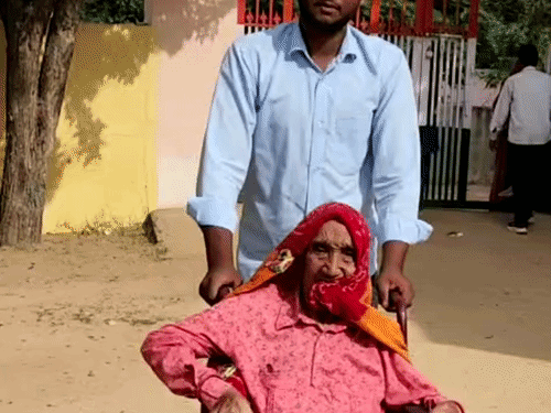 व्हीलचेयर पर मतदान के लिए पहुंची बुजुर्ग।