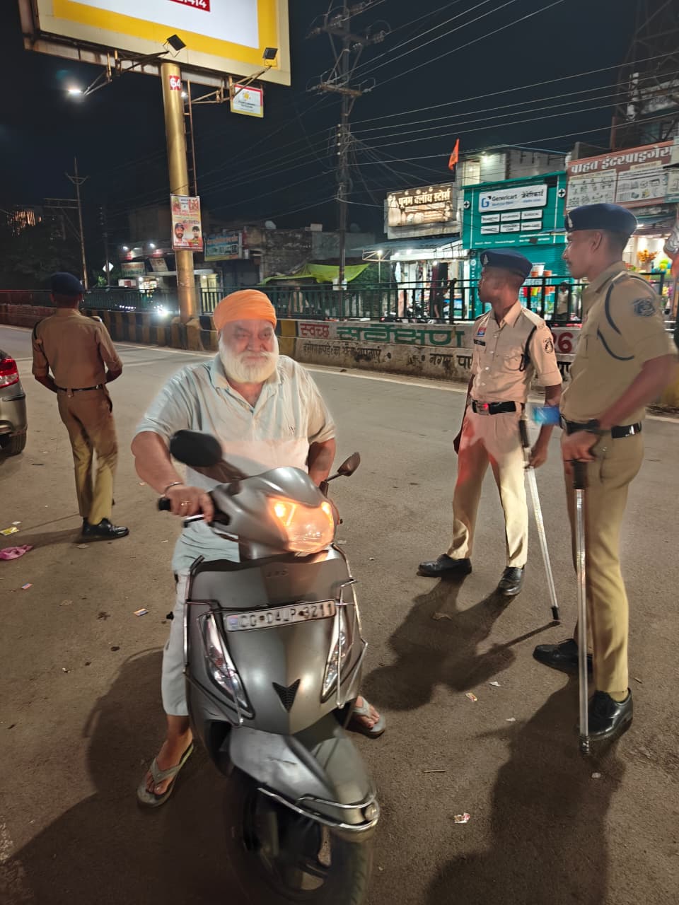 स्कूटी सवार को चेक करते पुलिसकर्मी।