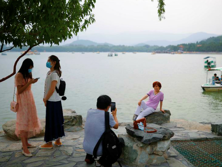 બીજિંગના એક લેકના કિનારે હાજર લોકો. ચીનમાં શુક્રવારે 21 નવા કેસ નોંધાયા હતા. તેમાંથી 17 બીજિંગના છે. લોકલ એડમિનિસ્ટ્રેશને કહ્યું કે, હોલસેલ માર્કેટ ફરીથી ખોલવા પર વિચાર કરવામાં આવ્યો નથી.