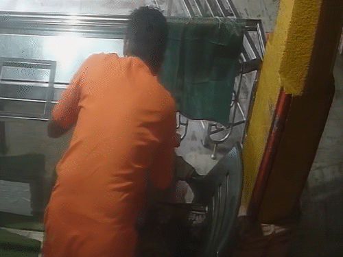 દાન પેટી પર પડી રહેલી ચલણી નોટો એકઠો કરતો પૂજારી.